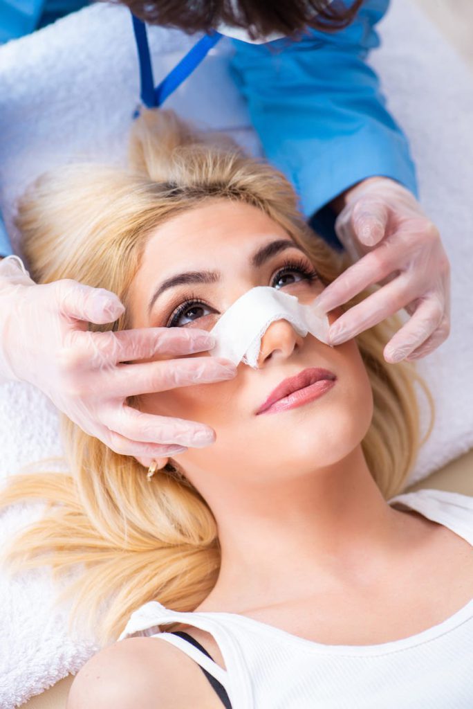 Patiente de rhinoplastie avec un pansement sur le nez