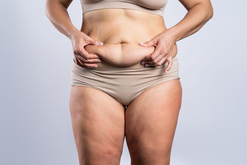 Mulher a tocar na sua grande barriga