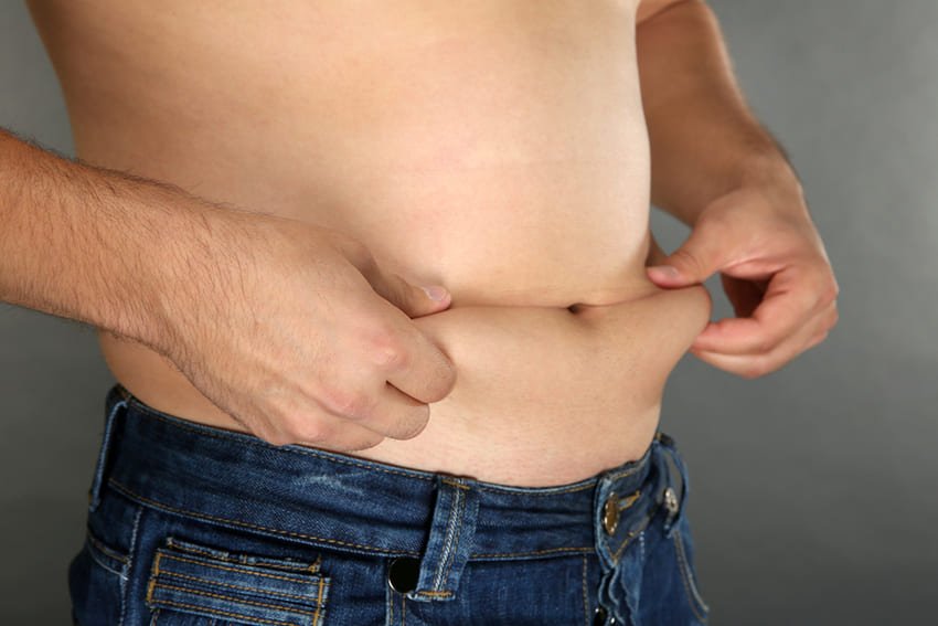 Um homem a tocar na sua grande barriga
